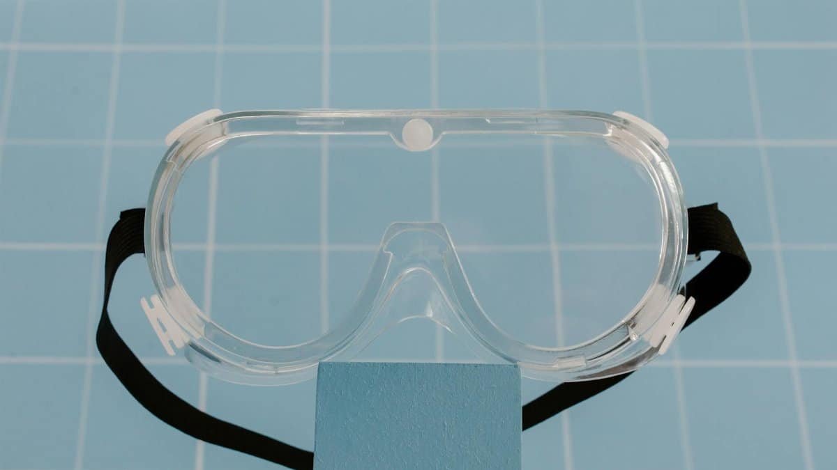 Clear protective goggles resting on a blue surface, ideal for safety and lab use.