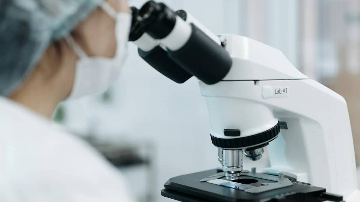 Scientist using a microscope in a laboratory environment. Focus on research and analysis.