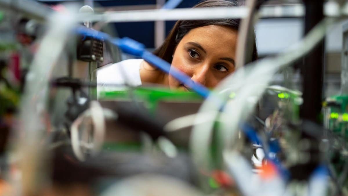 Focused female engineer analyzing equipment at a modern lab.