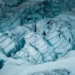 Stunning aerial capture of a striking glacier with deep icy crevices and snow-covered surface.