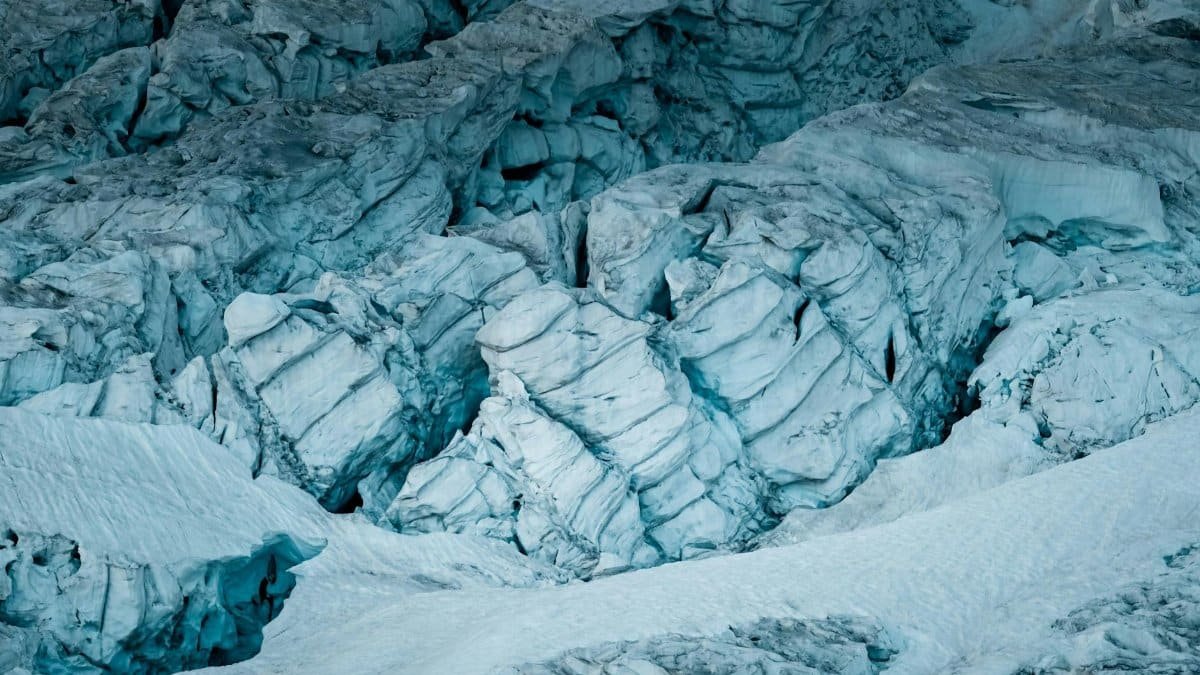Stunning aerial capture of a striking glacier with deep icy crevices and snow-covered surface.