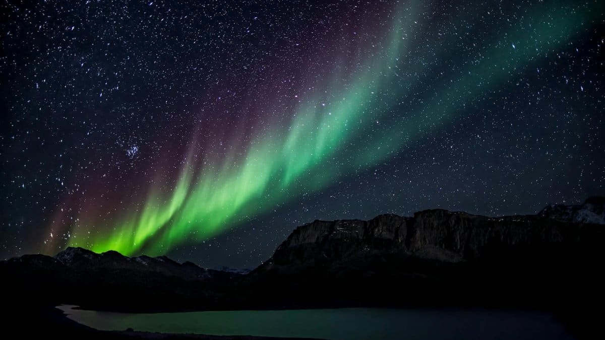 Mesmerizing aurora borealis illuminating the night sky over a serene landscape, capturing nature's beauty.