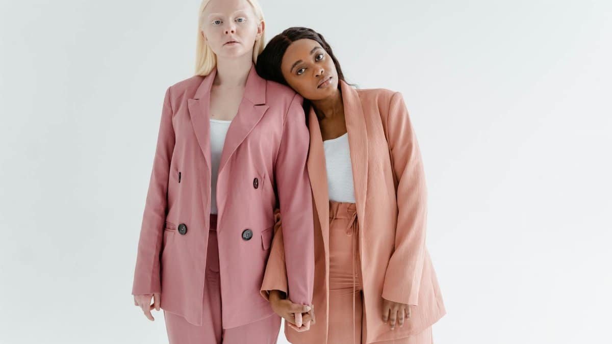 Two women in stylish blazers stand in solidarity, exemplifying unity and empowerment.