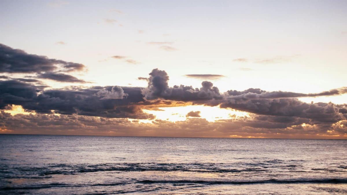 Tranquil ocean scene with clouds and sunset glow, perfect for relaxation themes.