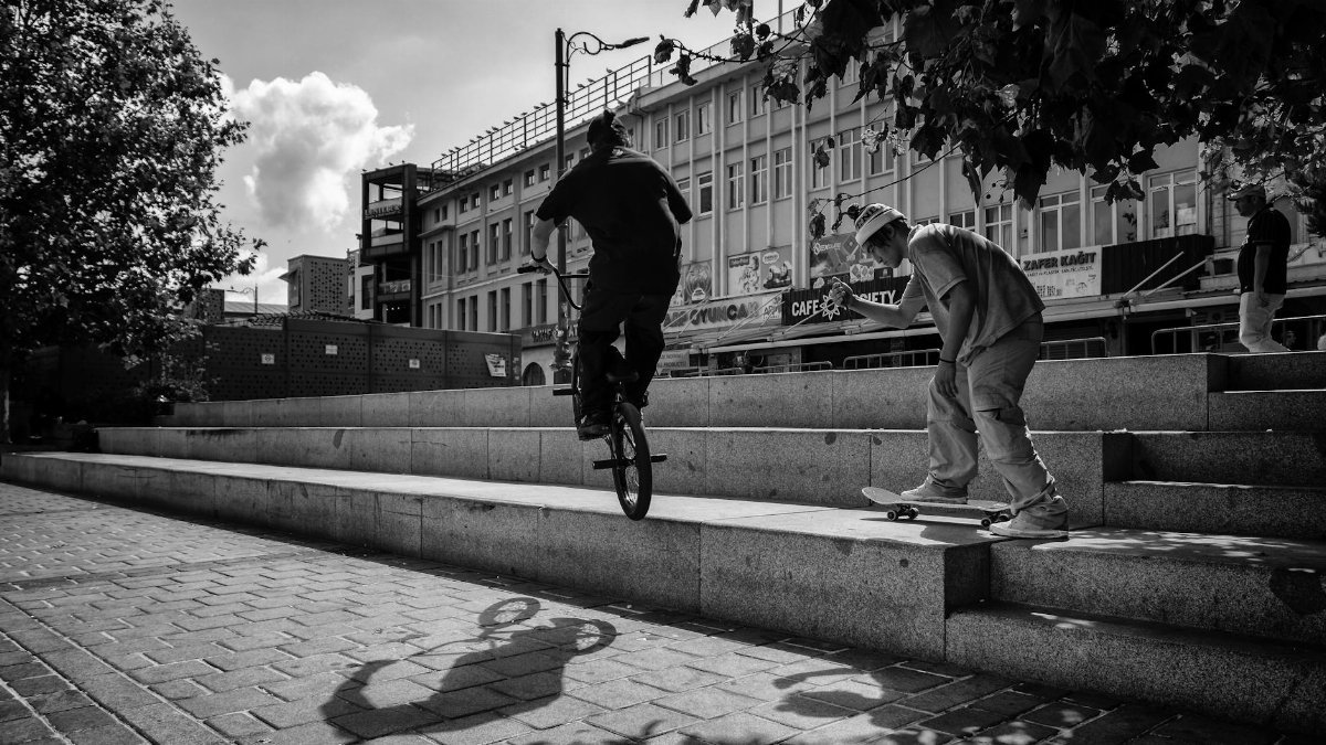 A dynamic street scene capturing skateboarding and BMX biking in Istanbul's urban setting.