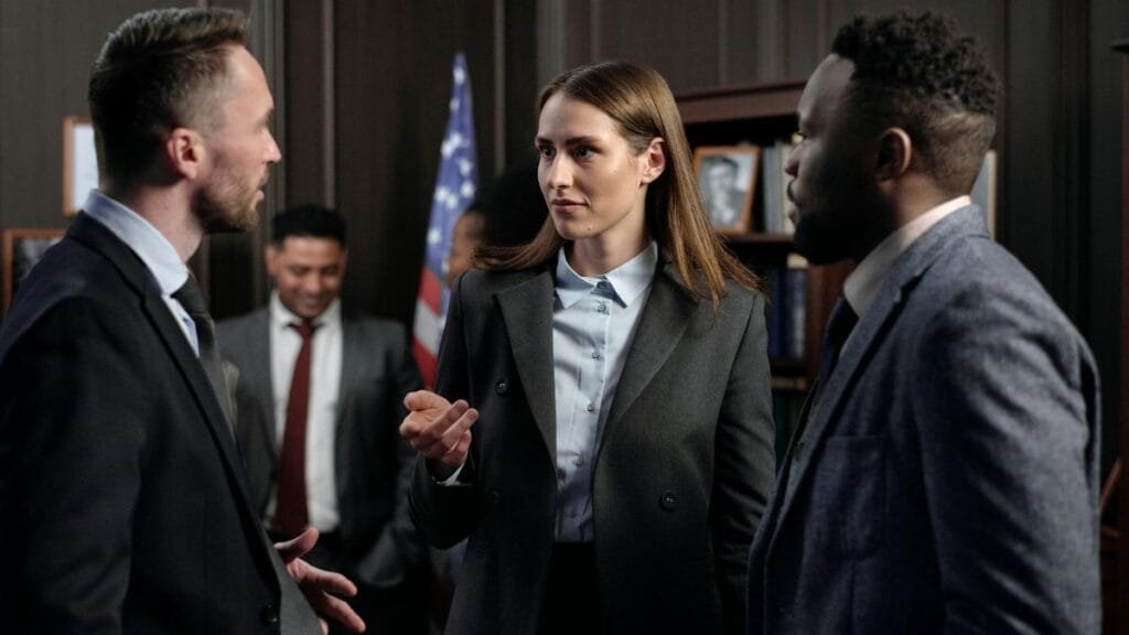 A diverse group of business professionals engaged in a discussion in an office.