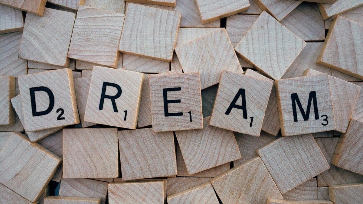 Close-up of wooden Scrabble tiles spelling the word 'DREAM', symbolizing creativity and imagination.