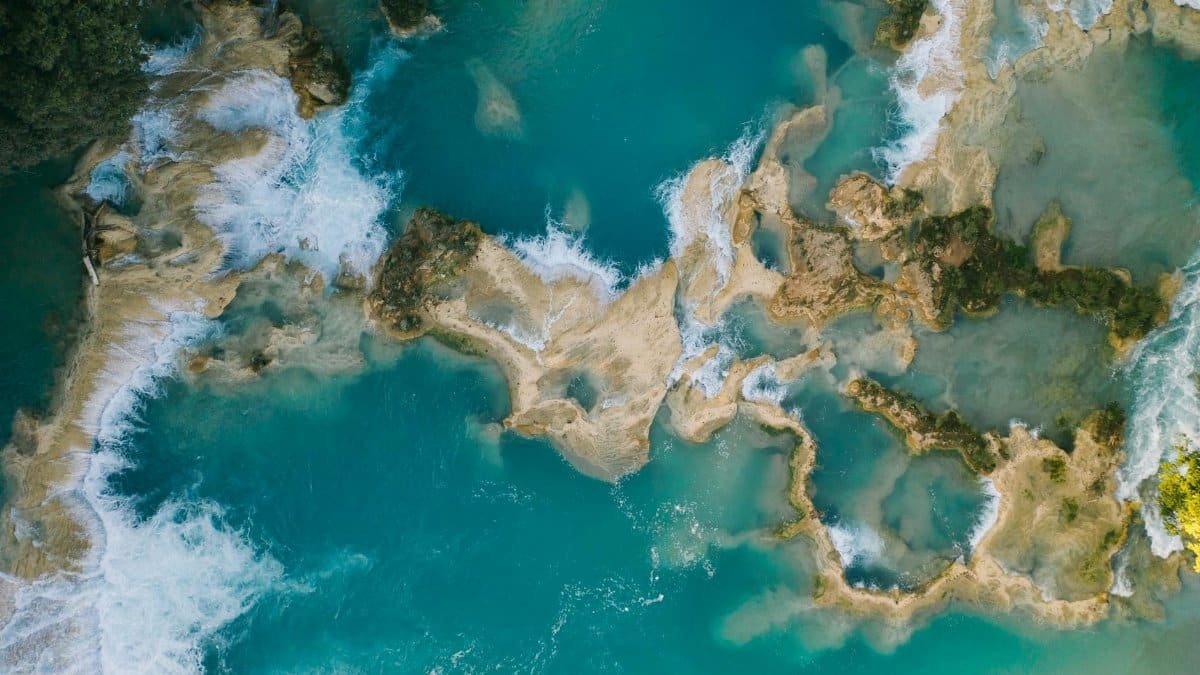 Stunning aerial capture of turquoise waterfalls in Chiapas, showcasing natural beauty and vibrant waters.