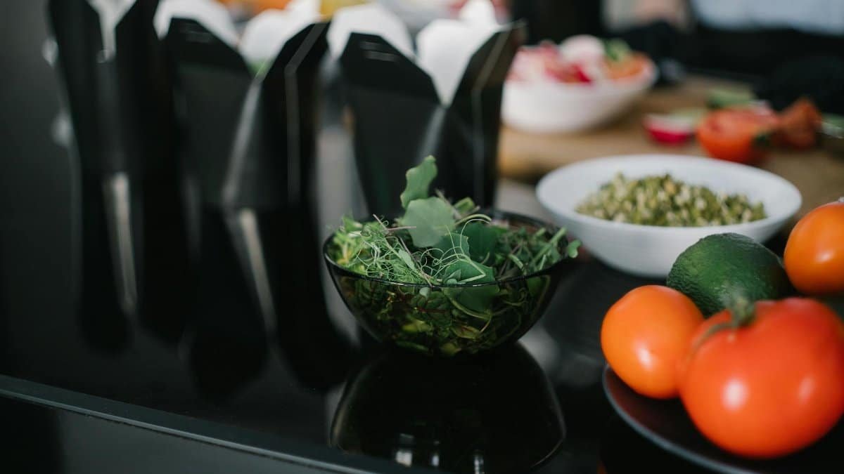 Close-up of fresh vegetables and takeout containers in a kitchen setting.