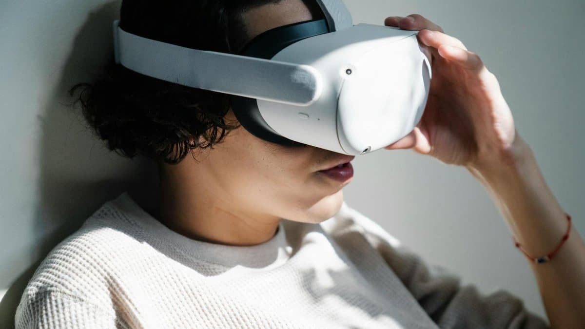 A woman immersed in a virtual reality experience with a VR headset indoors.