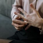 Close-up of a person removing a wedding ring, symbolizing relationship change or decision.