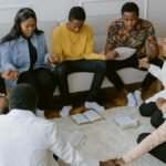 A group of people holding hands in prayer, creating a sense of unity.