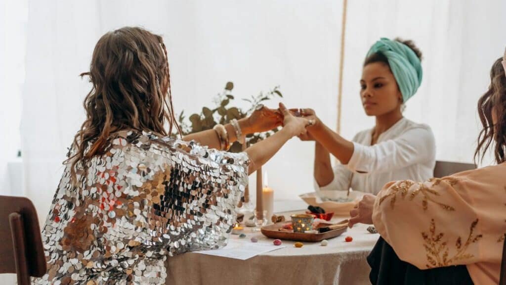 Three women practicing a spiritual ritual indoors, fostering connection and balance.