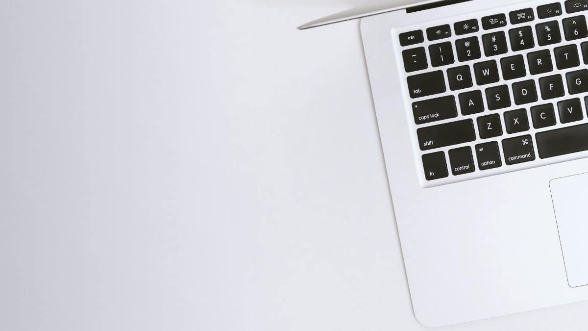 Aerial view of a sleek laptop keyboard on a clean, white surface, ideal for tech backgrounds.