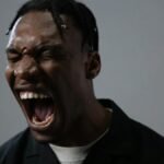 A powerful portrait capturing a man in a moment of intense emotion, possibly anger or frustration.