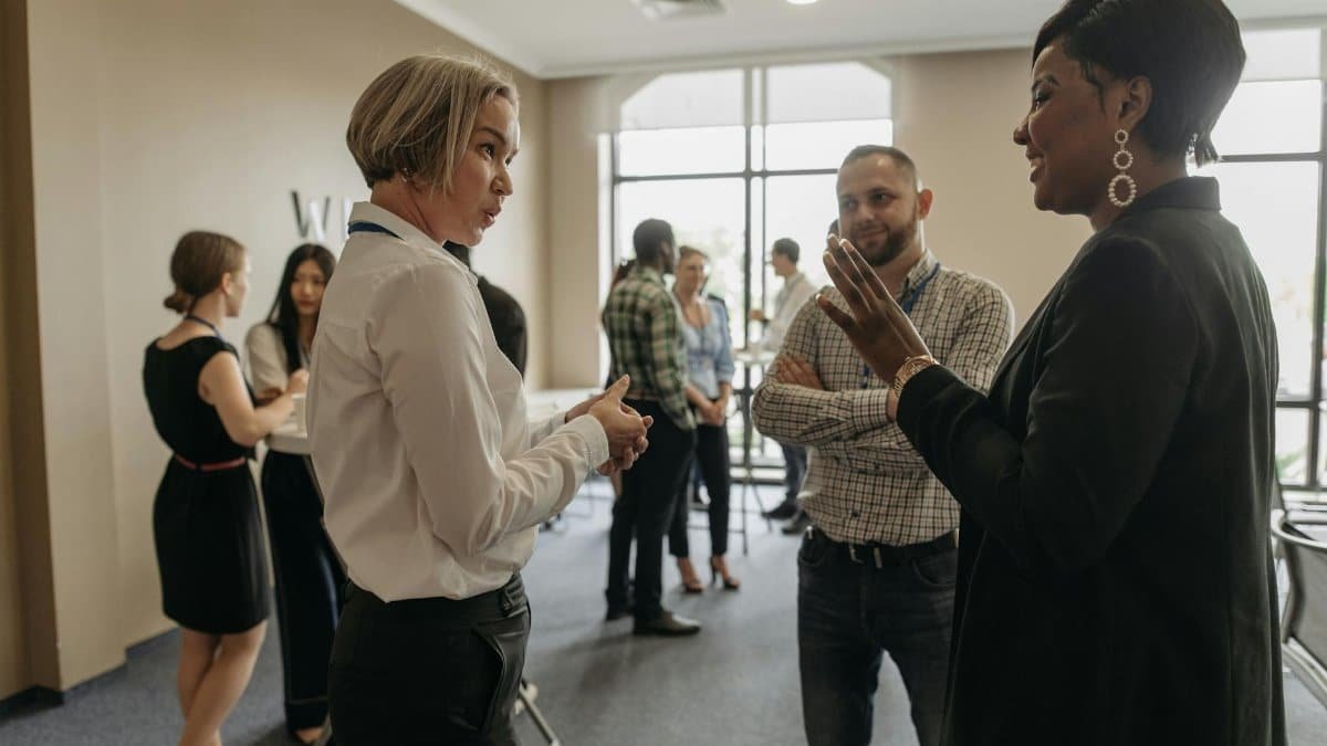 Professionals networking at a corporate event indoors, discussing and collaborating.