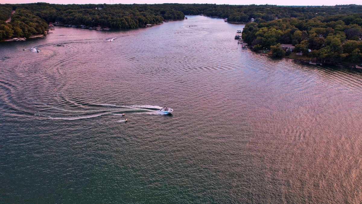 A stunning aerial view of boats gliding on a serene lake in Mound City, Kansas, surrounded by lush greenery.