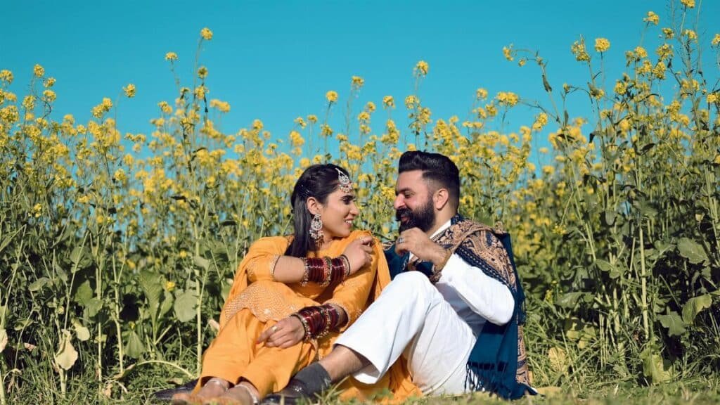 Happy couple enjoying a sunny day in a mustard field, embodying love and joy.