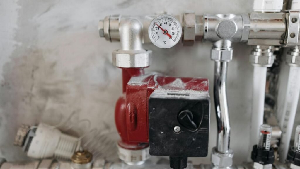Close-up view of an industrial plumbing system featuring a pressure gauge and steel pipes.