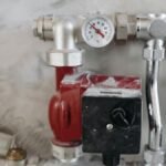 Close-up view of an industrial plumbing system featuring a pressure gauge and steel pipes.