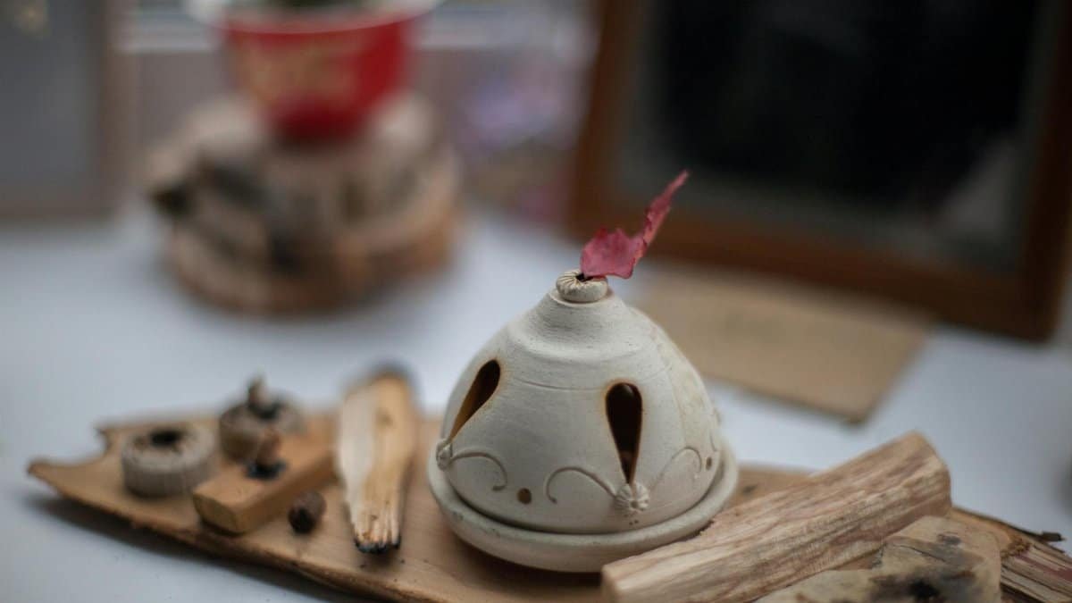 A ceramic incense burner on a wooden board, creating a serene atmosphere indoors.