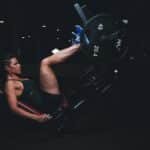 A woman engages in an intense leg press workout at the gym, showcasing strength and fitness.