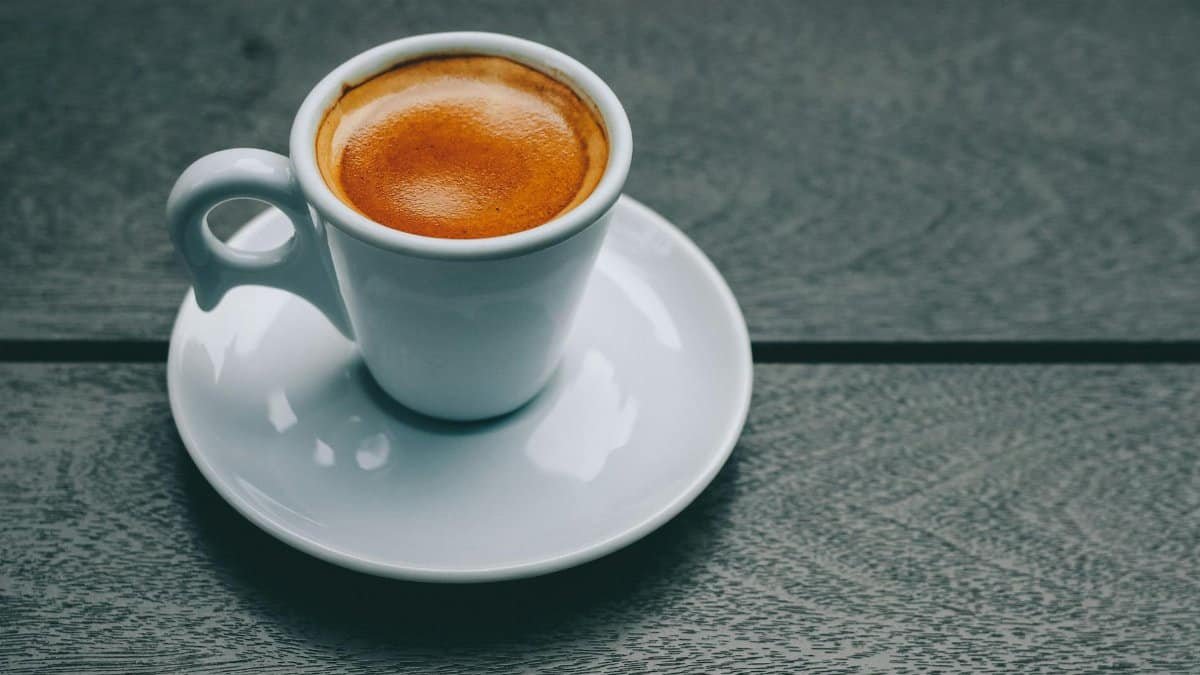 A stylish espresso in a porcelain cup on a wooden table, perfect for coffee lovers.