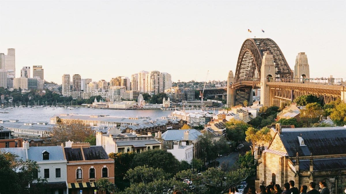 Captivating view of Sydney Harbour Bridge at sunset from Millers Point, NSW, with cityscape in the background.