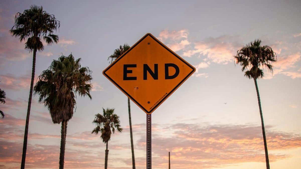 End sign amidst palm trees and sunset sky in Santa Monica, Los Angeles.