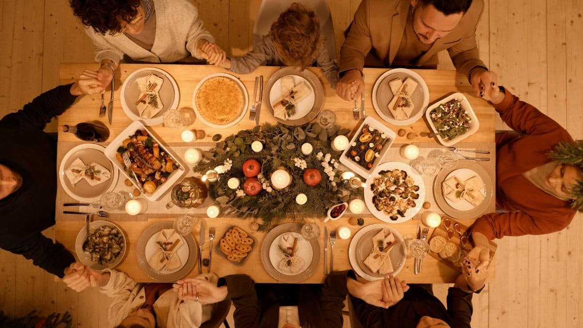 Family gathered around a beautifully set table for a festive Christmas dinner celebration.