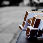 Artistic cube puzzle placed on a surface in an urban setting, capturing depth and focus.
