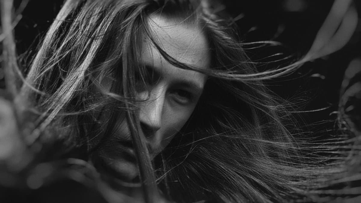 Dramatic black and white portrait highlighting expressive emotions and flowing hair.