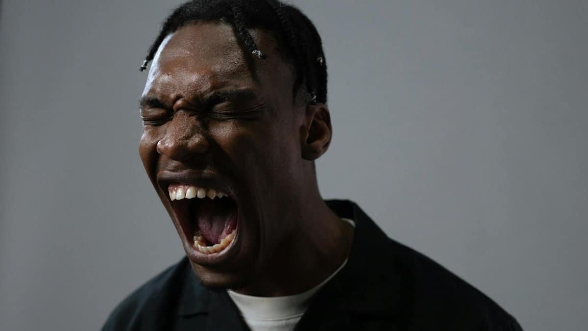 A powerful portrait capturing a man in a moment of intense emotion, possibly anger or frustration.