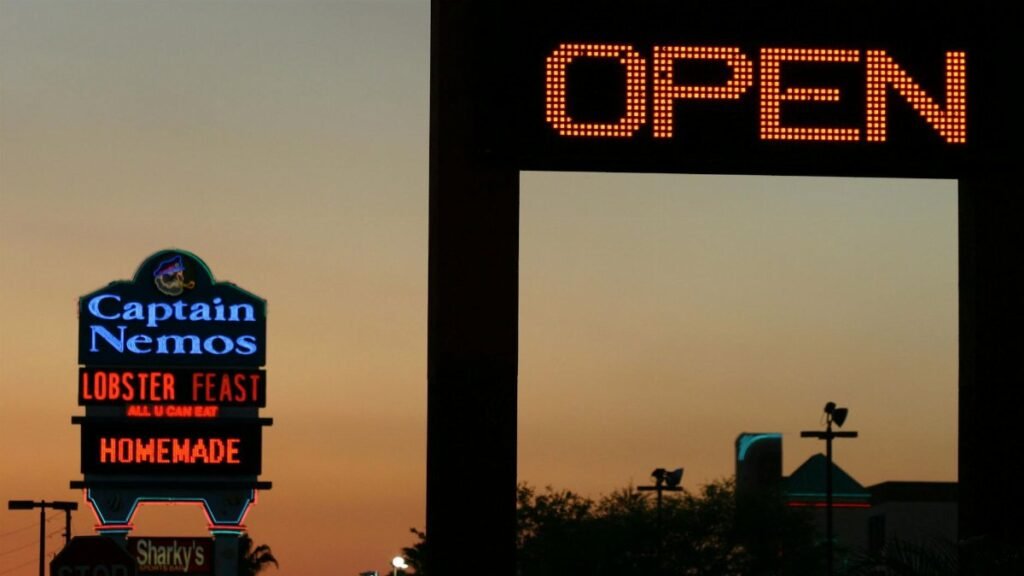 Neon signs light up the evening sky in Kissimmee, Florida. Vibrant nightlife is evident.