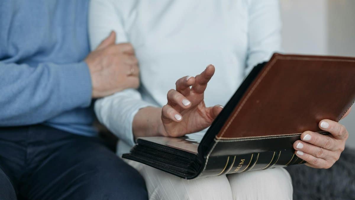 Close-up of a couple looking through a photo album, evoking nostalgia and memories.