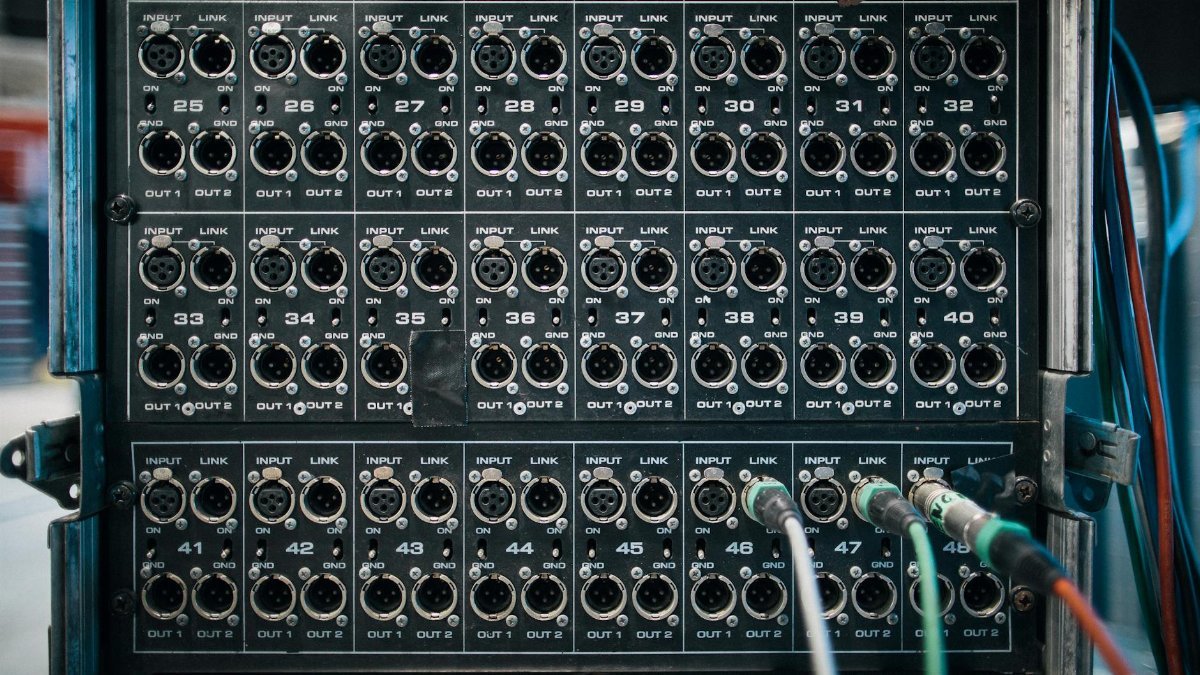 Assorted wires with connectors in sockets of sound reinforcement system with numbers in row on stage