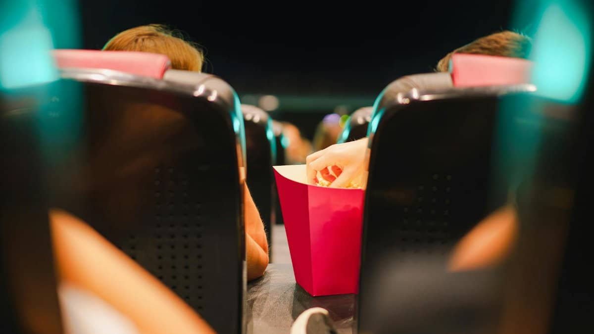 Group enjoying popcorn in a contemporary cinema setting, enhancing the movie experience.