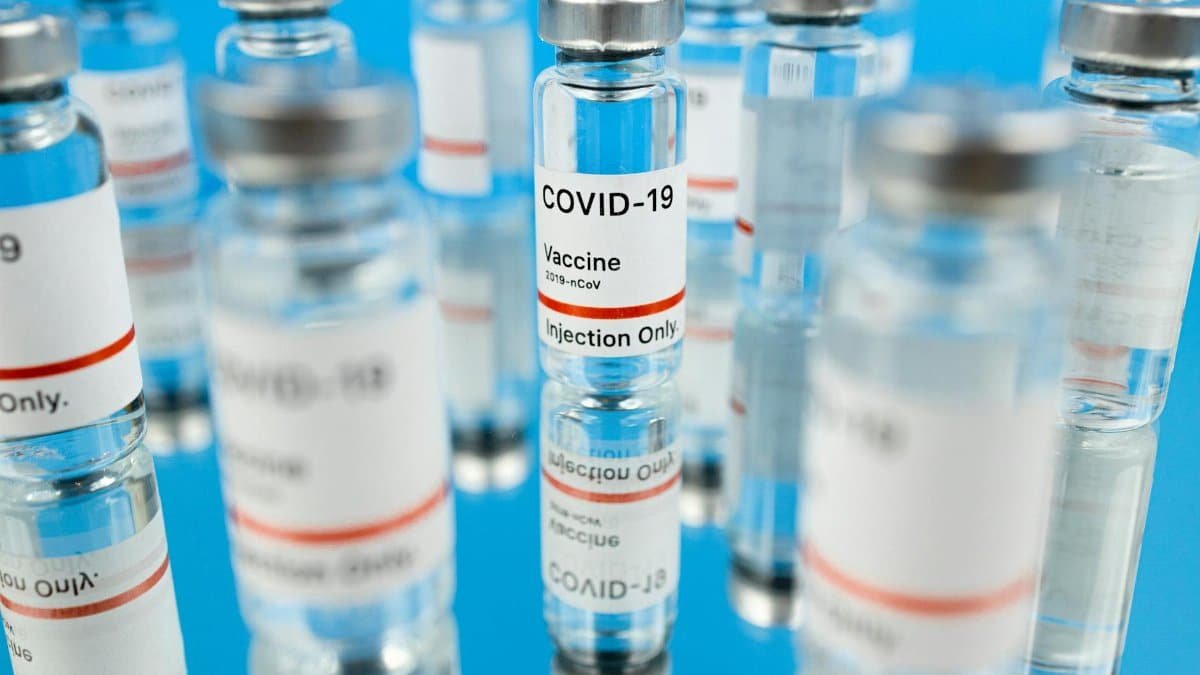Close-up of COVID-19 vaccine vials with syringe in a studio setting.