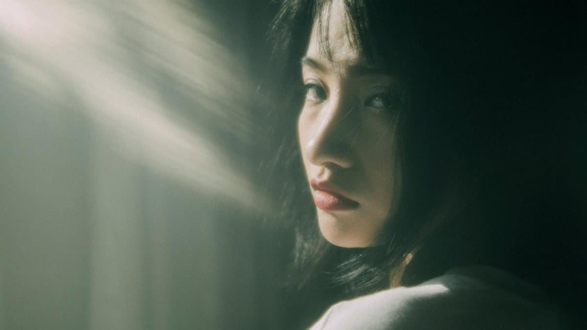 Portrait of a thoughtful young woman in soft sunlight, creating a dreamy and contemplative mood.