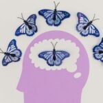 Creative illustration of butterflies representing thoughts over a brain silhouette.