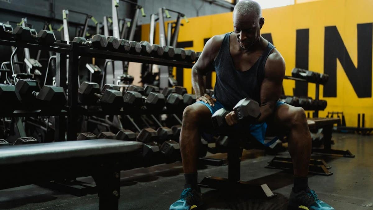 A muscular man lifting weights in a gym, highlighting strength and dedication.