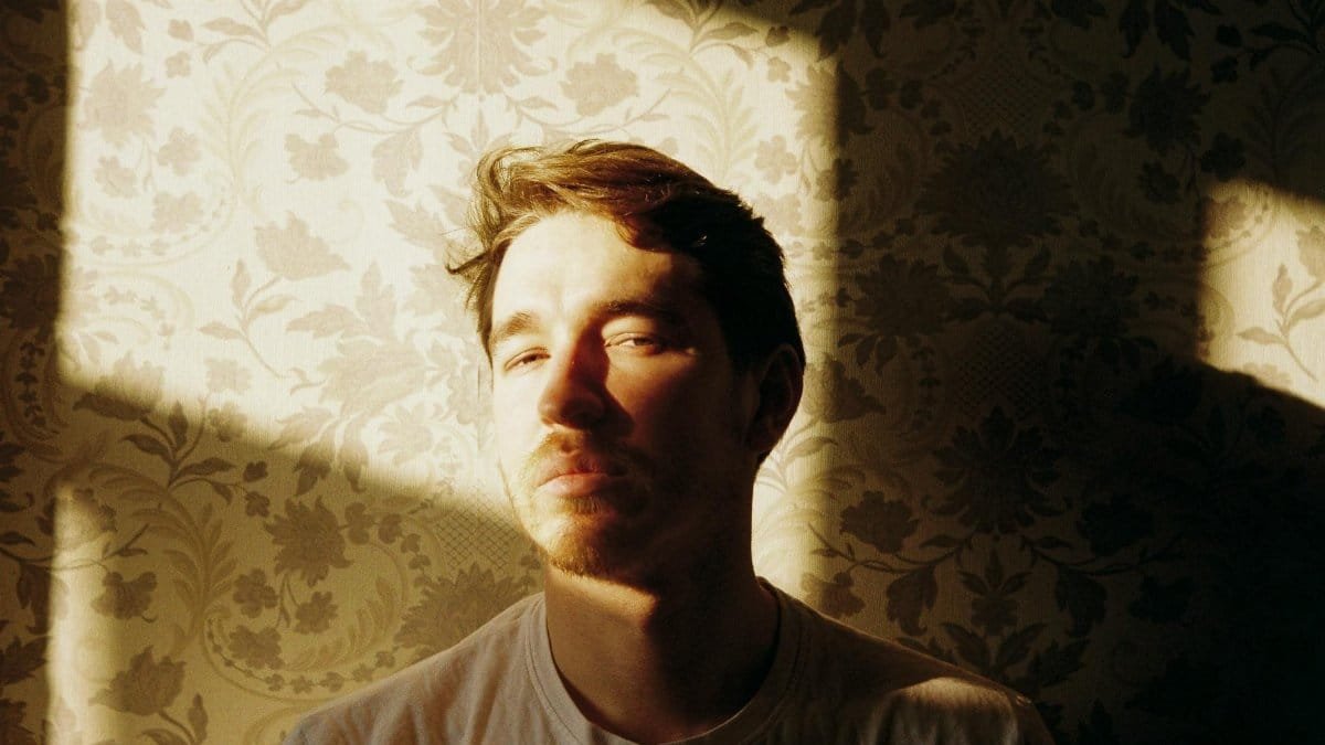 Aesthetic portrait of an adult man in autumn sunlight, conveying a vintage feel with deep shadows.