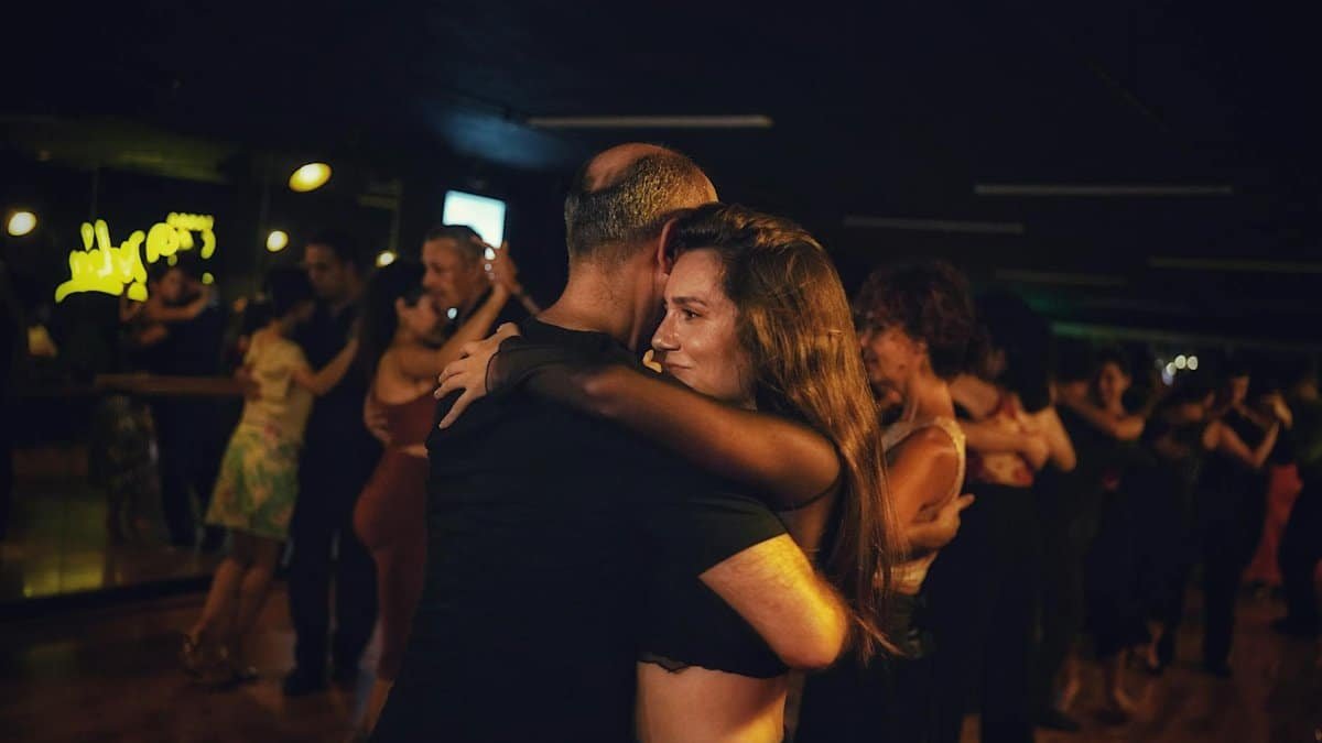 A captivating image of a couple dancing closely in a dimly lit nightclub setting.