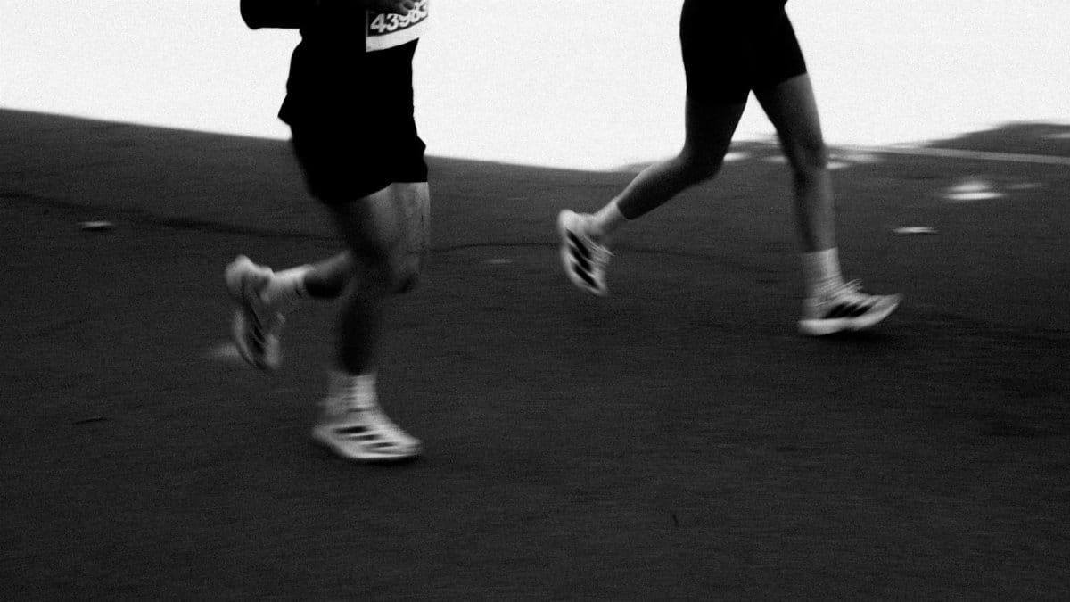 Dynamic black and white shot of marathon runners captured mid-stride, emphasizing movement and athleticism.