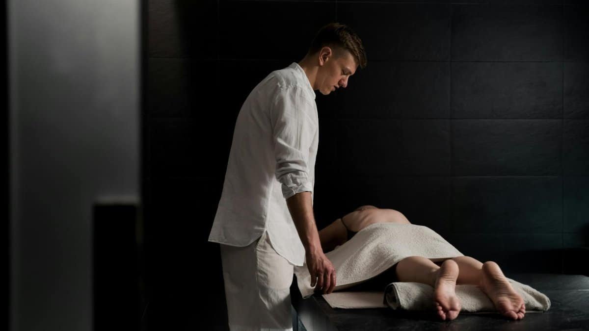 Therapist providing a relaxing massage in a serene spa setting, promoting wellbeing and relaxation.
