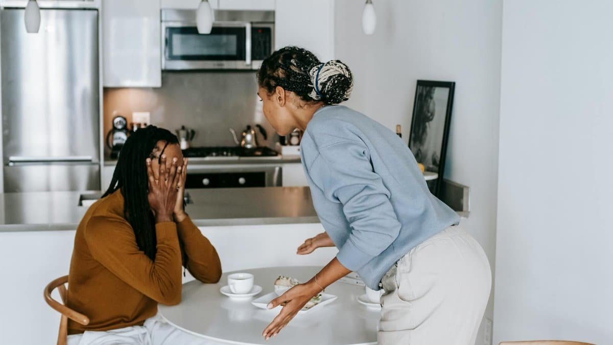 A young couple engaged in an intense discussion in a modern kitchen setting, showcasing emotional expression.