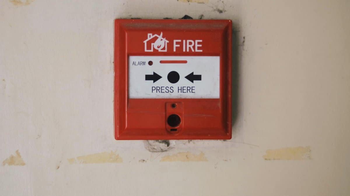 Emergency safety fire detection system box for safety with inscription and push button placed on white wall in light room