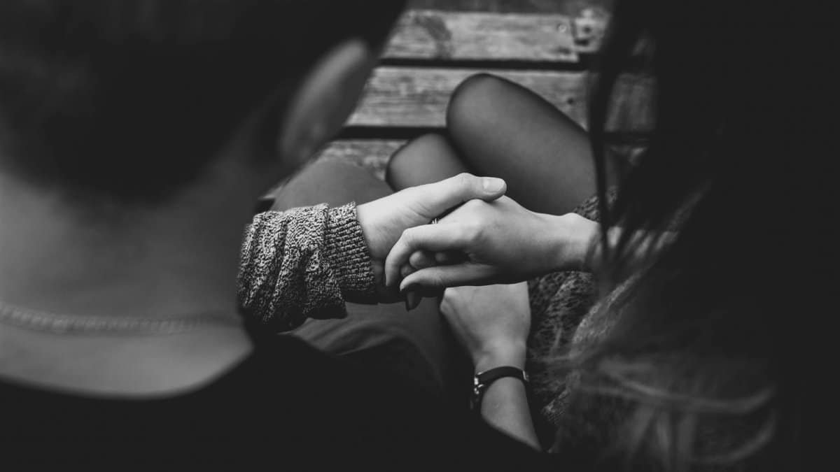 A romantic black and white image of a couple holding hands, symbolizing love and connection.