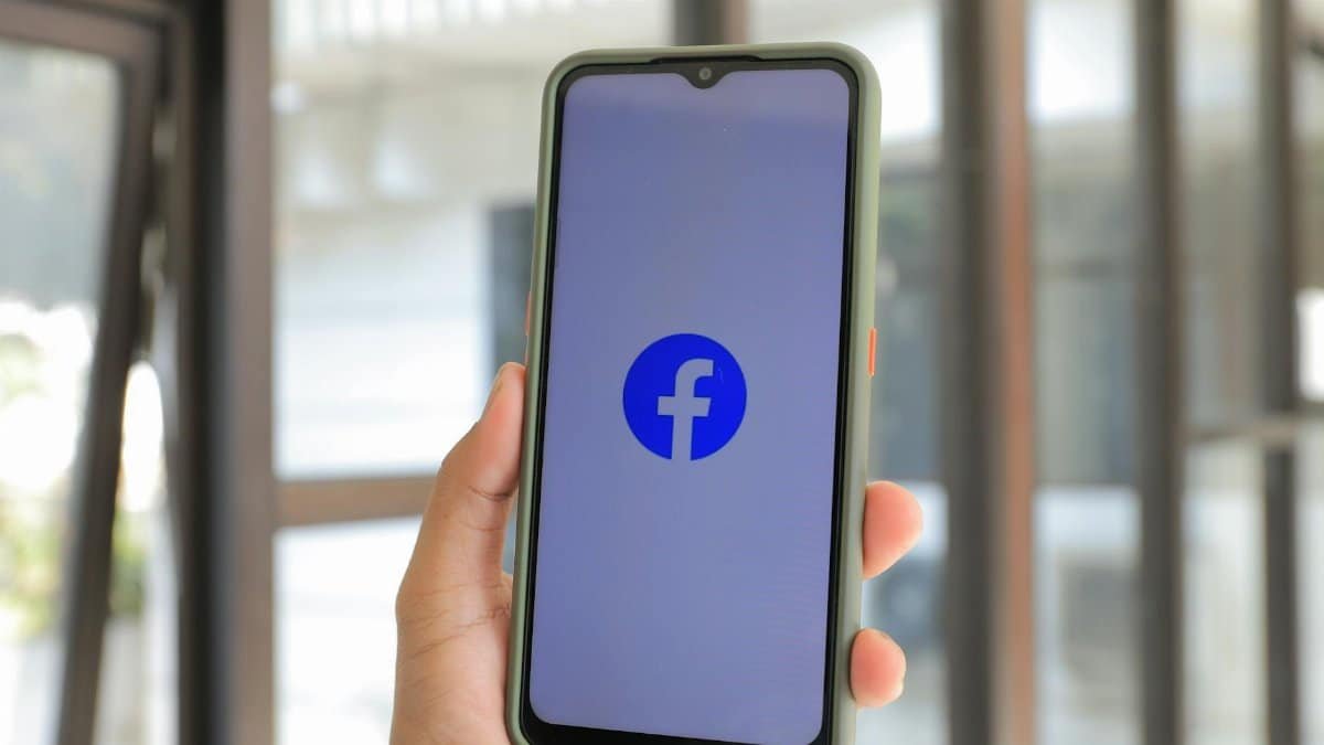 Close-up of smartphone with Facebook app open held by hand indoors.