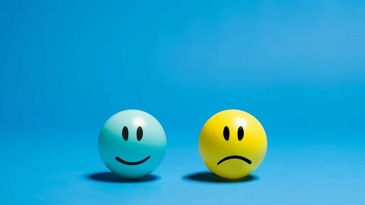 Two smiley balls representing opposite emotions on a blue background.